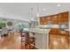 Open kitchen layout featuring a large island with seating, wooden cabinets, and hardwood floors at 5424 Hacienda Pl, Parker, CO 80134