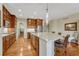 Bright kitchen featuring a large island, wooden cabinets, hardwood floors, and stainless appliances at 5424 Hacienda Pl, Parker, CO 80134