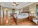 Primary bedroom with hardwood floors, tray ceiling, and decorative furniture at 5424 Hacienda Pl, Parker, CO 80134