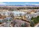 Aerial view of condominium complex near lake featuring mountain views in the background at 10530 W Jewell Ave # 303, Lakewood, CO 80232