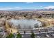 Aerial view of condominium complex near lake featuring mountain views in background at 10530 W Jewell Ave # 303, Lakewood, CO 80232
