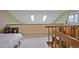 Lofted bedroom showcasing skylights, natural light, and neutral tones with wood banister overlooking the stairs at 10530 W Jewell Ave # 303, Lakewood, CO 80232
