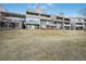 Back of condominium building showing balconies and patios with grassy hill at 10530 W Jewell Ave # 303, Lakewood, CO 80232