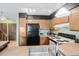Kitchen with oak cabinets, tile countertops, and black appliances with a view to the stairs at 10530 W Jewell Ave # 303, Lakewood, CO 80232