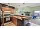 View of the kitchen with wood cabinets opening to living room with fireplace and bar seating at 10530 W Jewell Ave # 303, Lakewood, CO 80232