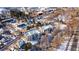 Winter aerial view of an apartment complex with snow-covered roofs, surrounded by trees and a road, showing the community's layout at 315 Arapahoe Ave # 202, Boulder, CO 80302
