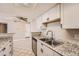 Kitchen featuring granite countertops, stainless steel sink, and white cabinetry at 931 S Zeno Way # 107, Aurora, CO 80017