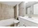 Updated bathroom boasts a shower-tub, tile surround, and a white vanity with sink at 18004 E Ohio Ave # 101, Aurora, CO 80017