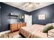 Charming bedroom featuring textured walls, wood floors, ceiling fan and lovely mid-century modern dresser at 3116 S Lincoln St, Englewood, CO 80113