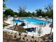 A large community pool filled with people, lounge chairs, and umbrellas sits under a bright blue sky at 8101 S San Juan Range Rd, Littleton, CO 80127