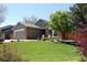 Well-maintained exterior of a home with green lawn and mature trees at 8101 S San Juan Range Rd, Littleton, CO 80127