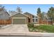 A well-maintained home with a two-car garage, brick accents, and a manicured lawn at 8101 S San Juan Range Rd, Littleton, CO 80127
