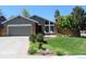 Charming brick home with a well-manicured lawn, flower beds, and an attached two-car garage at 8101 S San Juan Range Rd, Littleton, CO 80127