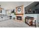 Cozy living room with a brick fireplace, plush carpet, and comfortable seating arrangement at 8101 S San Juan Range Rd, Littleton, CO 80127