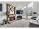 Bright living room featuring a brick fireplace, large windows, and a comfortable seating area at 8101 S San Juan Range Rd, Littleton, CO 80127