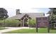 The recreation center at Bradford Park is surrounded by bushes, a sign, and large trees on a grassy lawn at 8101 S San Juan Range Rd, Littleton, CO 80127