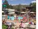 A community swimming pool with water slides, lounge chairs, and many swimmers enjoying a summer day at 8101 S San Juan Range Rd, Littleton, CO 80127