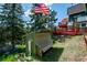 Private backyard featuring mature trees and a tiered deck, perfect for outdoor entertaining at 32392 Lodgepole Dr, Evergreen, CO 80439