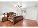 Bedroom featuring a large bed with decorative headboard, ceiling fan, and wood laminate floors at 32392 Lodgepole Dr, Evergreen, CO 80439