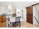Bright dining area with hardwood floors and barn door, adjacent to the kitchen, perfect for gatherings at 32392 Lodgepole Dr, Evergreen, CO 80439