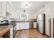 Well-lit kitchen features wood floors, stainless steel refrigerator, and white cabinetry at 32392 Lodgepole Dr, Evergreen, CO 80439