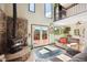 Bright living room features a stone fireplace, large windows, and access to a deck with scenic mountain views at 32392 Lodgepole Dr, Evergreen, CO 80439