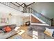 Bright, open living area with high ceilings, stone fireplace, and staircase leading to the upper level at 32392 Lodgepole Dr, Evergreen, CO 80439