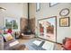Cozy living room features a stone fireplace, hardwood floors, natural light, and access to the outdoor deck at 32392 Lodgepole Dr, Evergreen, CO 80439