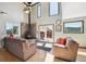 Spacious living room boasts a stone fireplace, large windows, and comfortable seating, opening to an outdoor deck at 32392 Lodgepole Dr, Evergreen, CO 80439