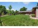 Large, well-manicured lawn extending from a charming brick home, surrounded by mature trees and landscaping at 3980 S Dexter St, Cherry Hills Village, CO 80113