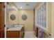 Traditional bathroom with stone countertop vanity, decorative wall art, and glass block window at 3980 S Dexter St, Cherry Hills Village, CO 80113