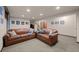 Cozy living room with plush brown leather couches, neutral carpeting, and recessed lighting at 3980 S Dexter St, Cherry Hills Village, CO 80113