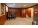 Basement dining area features a dark round table, seating for four, wood paneling, and carpeted floor at 3488 Dawson Rd, Sedalia, CO 80135
