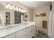 Bathroom with marble countertop, double sinks, and tiled shower with neutral colors and large mirrors at 3488 Dawson Rd, Sedalia, CO 80135