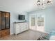 Light and airy bedroom with access to the walk-out deck and a flat screen TV above a white dresser at 3488 Dawson Rd, Sedalia, CO 80135