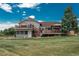 Two-story home with brick chimney, inviting deck, gazebo, and mature trees offers space for relaxation and gatherings at 3488 Dawson Rd, Sedalia, CO 80135