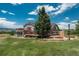 Large two-story home featuring an expansive deck, gazebo, mature trees, and access to lush, green backyard at 3488 Dawson Rd, Sedalia, CO 80135