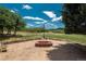 Outdoor fire pit area with rustic log seating and a serene landscape view at 3488 Dawson Rd, Sedalia, CO 80135