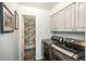 Well-lit laundry room with gray cabinets and gray front-loading washer and dryer for efficient laundry at 3488 Dawson Rd, Sedalia, CO 80135