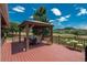 Covered patio on wooden deck with a table setting, flowers, chairs, and a view of the surrounding landscape at 3488 Dawson Rd, Sedalia, CO 80135