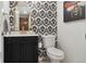 Chic powder room featuring a black vanity, statement wallpaper, and gold accents at 5149 E Links Cir, Centennial, CO 80122