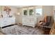 Bright Bedroom with stylish decor, featuring a crib, rocking chair, and large windows at 5149 E Links Cir, Centennial, CO 80122