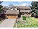Charming two-story home with a wooden garage door and landscaped front yard at 5149 E Links Cir, Centennial, CO 80122