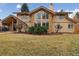 Well-maintained home exterior showcasing a large backyard, mature landscaping, and outdoor living space at 5149 E Links Cir, Centennial, CO 80122