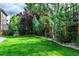 Lush backyard features well-manicured lawn, mature trees, and decorative landscaping, enhancing outdoor appeal at 9882 S Hoyt Ct, Littleton, CO 80127