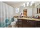 Bathroom featuring granite countertops, toilet, sink, vanity, shower, and a unique stained glass window at 9882 S Hoyt Ct, Littleton, CO 80127