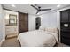 Bedroom with barn door to bathroom, ceiling fan, and black furniture at 9882 S Hoyt Ct, Littleton, CO 80127