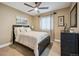 A serene bedroom featuring a ceiling fan, picture window, and calming neutral decor at 9882 S Hoyt Ct, Littleton, CO 80127