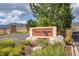 Community entrance sign surrounded by lush landscaping, trees and mountain views at 9882 S Hoyt Ct, Littleton, CO 80127