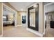 Well-lit hallway featuring neutral tones, a large decorative mirror, and access to bedrooms and office space at 9882 S Hoyt Ct, Littleton, CO 80127